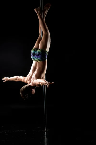Male pole dance. Guy posing upside down on pylon — Stock Photo, Image
