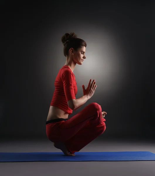 Yoga no estúdio. Menina fazendo asana, no fundo cinza — Fotografia de Stock