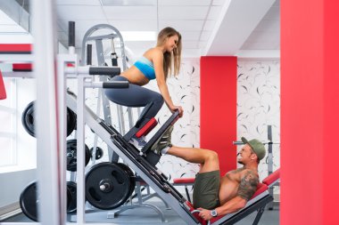 Spor salonunda. Neşeli sporcular üzerinde simülatörü egzersiz