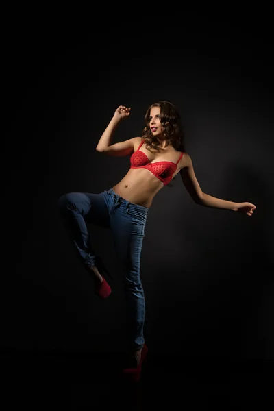 Beautiful caucasian model posing in bra and jeans — Stock Photo, Image