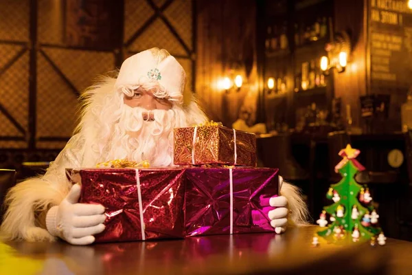 Święty Mikołaj z kupą prezentów w barze — Zdjęcie stockowe