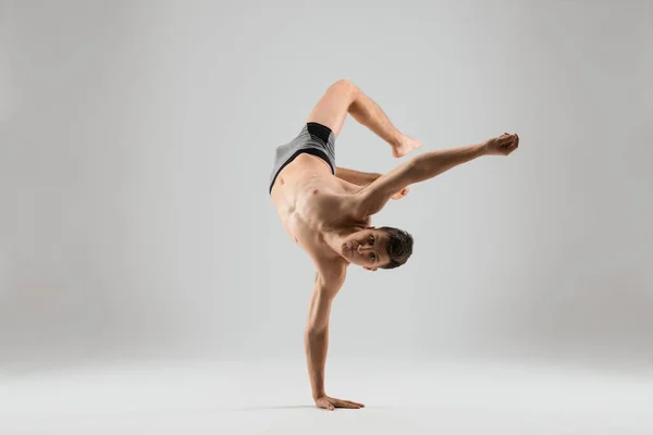 Flexible man dancing breakdance on one hand — Stock Photo, Image