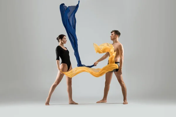 Jeune couple de danseurs avec un tissu coloré — Photo