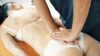 Ekin osteopat elleri kadın hastaya masaj yapıyor.