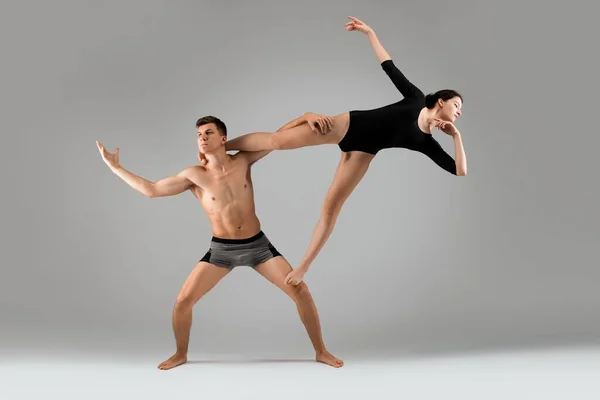 Грациозная молодая пара делает гимнастические упражнения вместе — стоковое фото