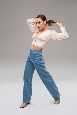 Şık giyinmiş enerjik bir kadın stüdyoda yürüyor.