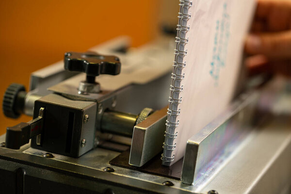 Spiral notebook and machine in workshop