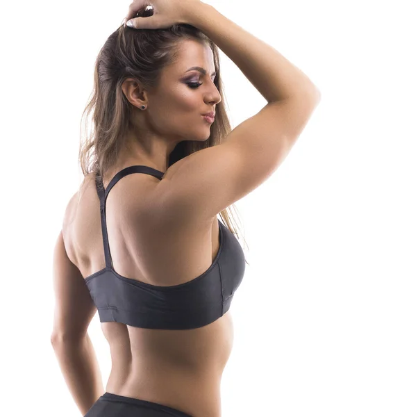 Muscular athletic female in bra, panties and sneakers sitting in balasana  pose, relaxing back after intensive workout with dumbbells in gym.  Unrecognizable woman having rest during training Stock Photo