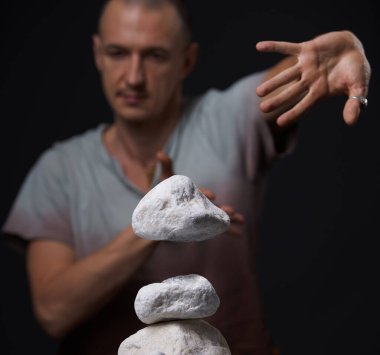 Yoga pozisyonunda yerde oturan bir adam stüdyo çekimi yapıyor.