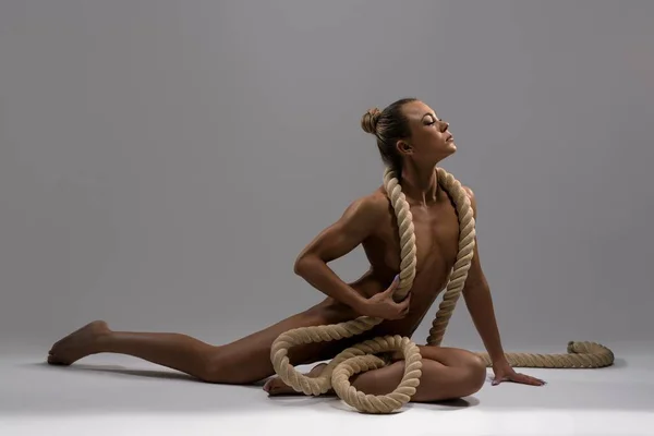 Graciös naken idrottskvinna med rep i studio — Stockfoto