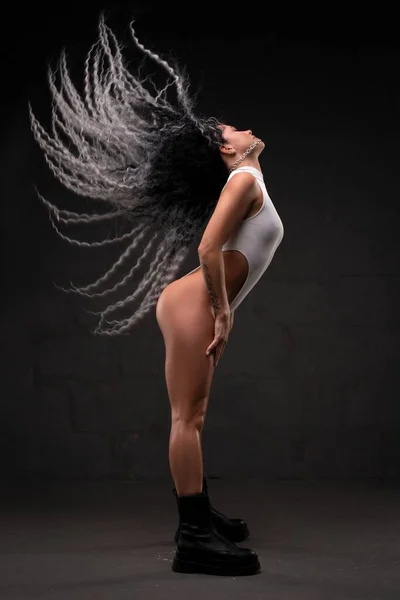 Verführerische ethnische Frau mit fliegendem Haar im Studio — Stockfoto