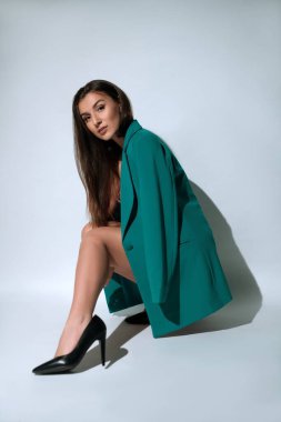 Ceketli ve topuklu ayakkabılı şık bir kadın.