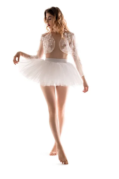 Barefoot ballerina in translucent shrug touching skirt — Stock Photo, Image
