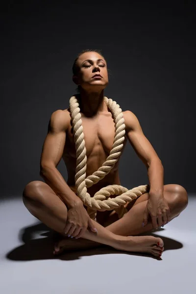 Gracieuse sportive nue avec corde sur le sein en studio — Photo