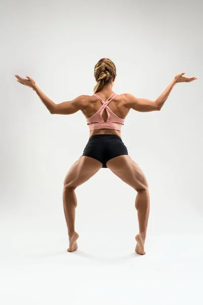 Femme musculaire en sous-vêtements de sport debout dans la pose de la déesse — Photo