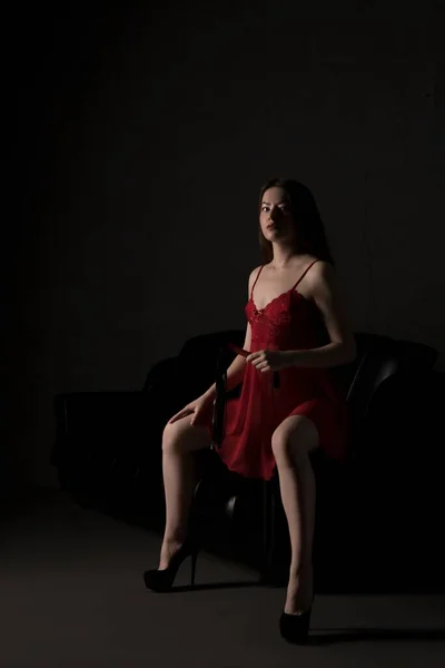Sexy Frau in roter Unterwäsche mit BDSM-Accessoires — Stockfoto