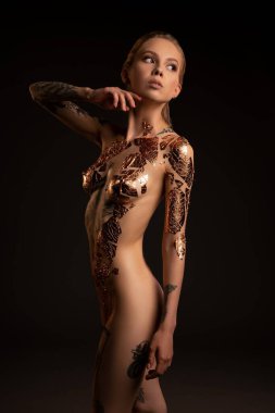 Vücudunda parlak bantlar olan zarif çıplak kadın.