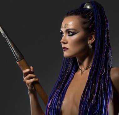 Rastalı, üstsüz, profil görünümlü bir kadın.