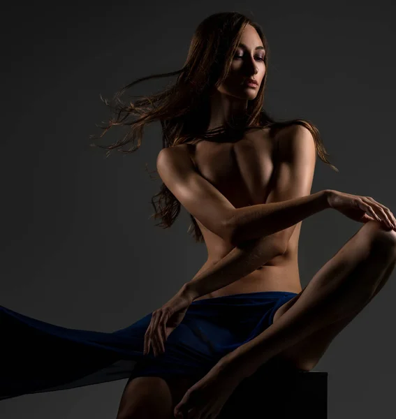 Bruna sottile con panno blu nudo su un cubo — Foto Stock