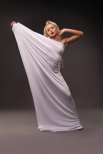 Sexy woman wrapped in white cloth in studio — Stock Photo, Image