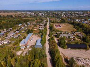 Sonbaharda yemyeşil ağaçlar ve evler arasındaki yol