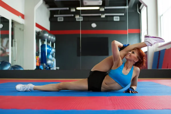 Funny sportswoman stretches at camera in gym — Stock Photo, Image