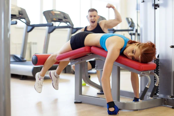 Veselý muž a žena unavená z tréninku v tělocvičně — Stock fotografie
