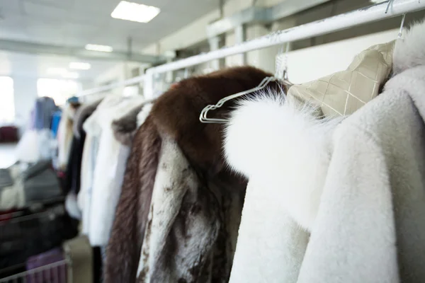 Roupas limpas penduradas em cabides em lavandarias — Fotografia de Stock