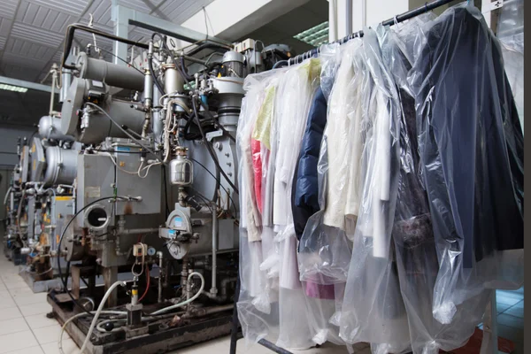 Clean packed clothes hanging in dry cleaning — Stock Photo, Image