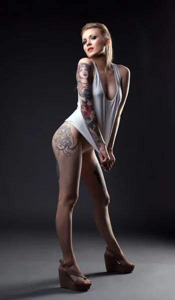 Modelo sexy com tatuagens posando em camiseta cinza — Fotografia de Stock