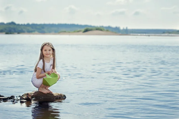 Jolie fille se préparant à lancer bateau en papier au lac — Photo