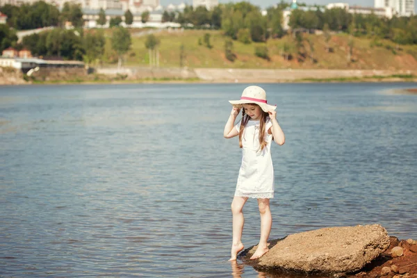 Curious little girl walking along river bank — Stock Photo, Image