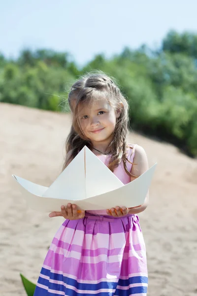 Carino bambina in posa con barca di carta — Foto Stock