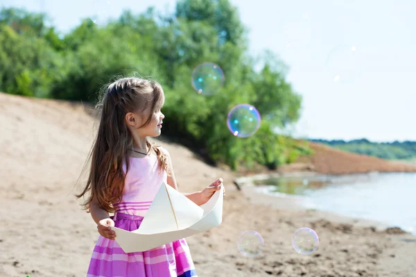 Nice little girl playing with paper boat — Stock Photo, Image