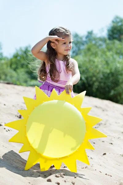 Curiosa giovane ragazza in posa con sole di carta — Foto Stock