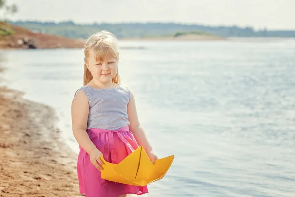 Schönes blondes Mädchen posiert mit hausgemachtem Papierboot — Stockfoto