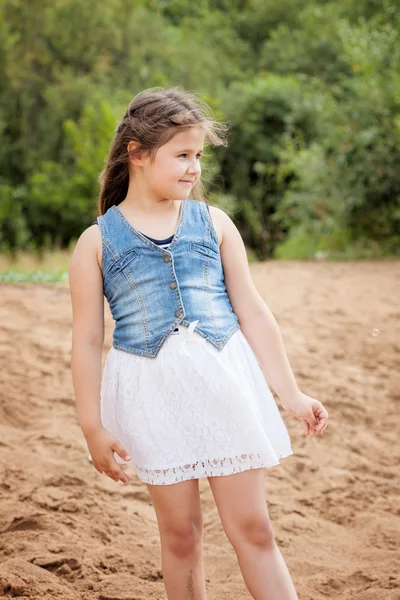 Entzückendes Mädchen posiert in lässiger Kleidung am Strand — Stockfoto