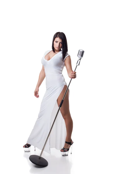 Sexy woman in long dress posing with microphone — Stock Photo, Image