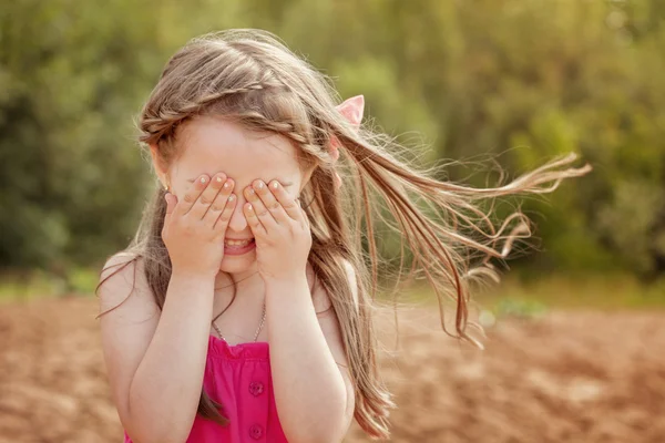 Schattig klein meisje spelen verstoppertje met camera — Stockfoto
