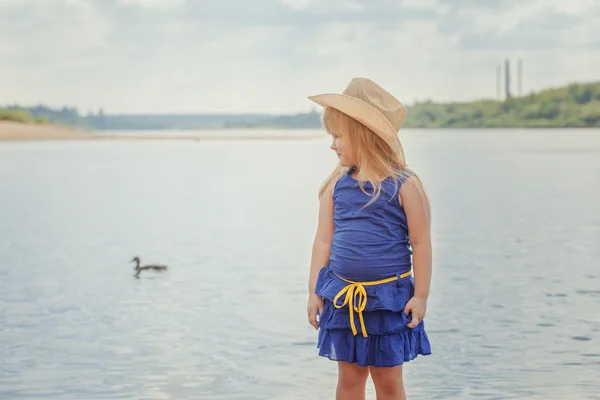 Grappige blonde meisje die zich voordeed op achtergrond van lake — Stockfoto
