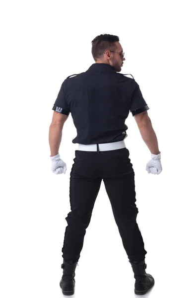 Policia muscular elegante posando de volta para a câmera — Fotografia de Stock