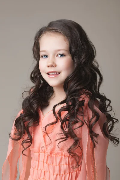 Portrait of adorable girl posing in coral dress — Stock Photo, Image