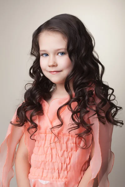 Pretty little brunette in coral dress — Stock Photo, Image