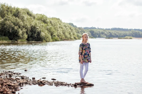 Jolie jeune fille posant pieds nus sur la rive du lac — Photo