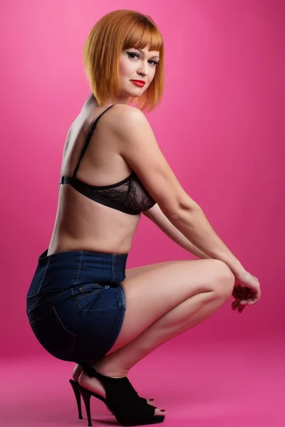 Redhead slank model poseren op roze achtergrond — Stockfoto