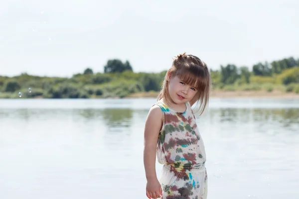 Lachende meisje poseren door rivier — Stockfoto