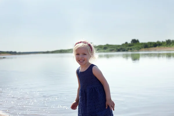 Porträt eines glücklichen kleinen Mädchens, das am See ruht — Stockfoto