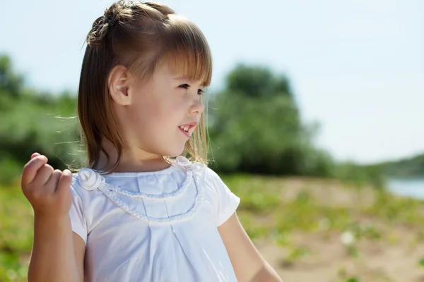 Portrait of merry little girl posing in park — Stock Photo, Image