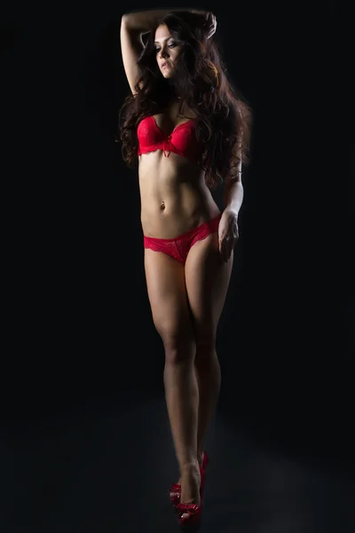 Sensuele brunette poseren in erotische rode lingerie — Stockfoto