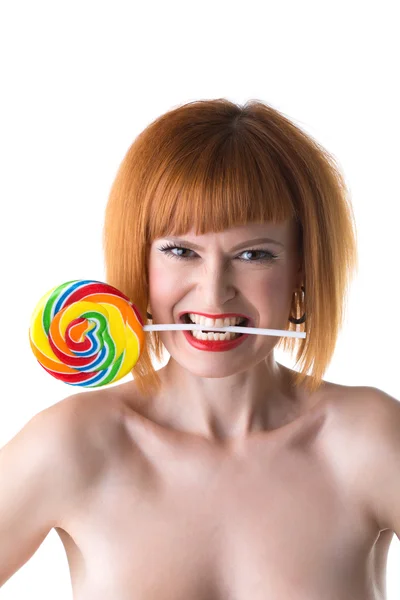 Funny redhead woman squeezes lollipop by teeth — Stock Photo, Image